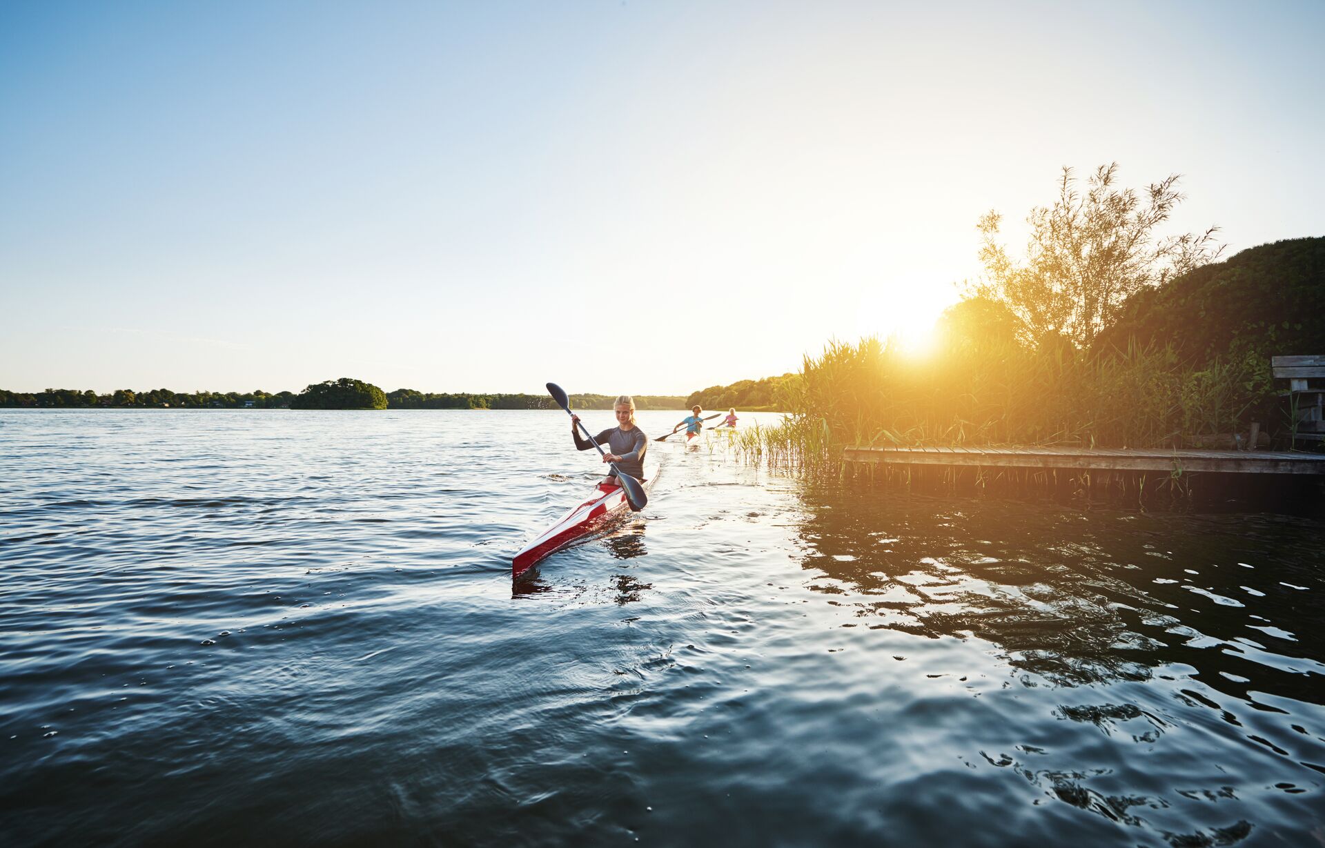 Three people kayaking on the water, paddlesports concept. 