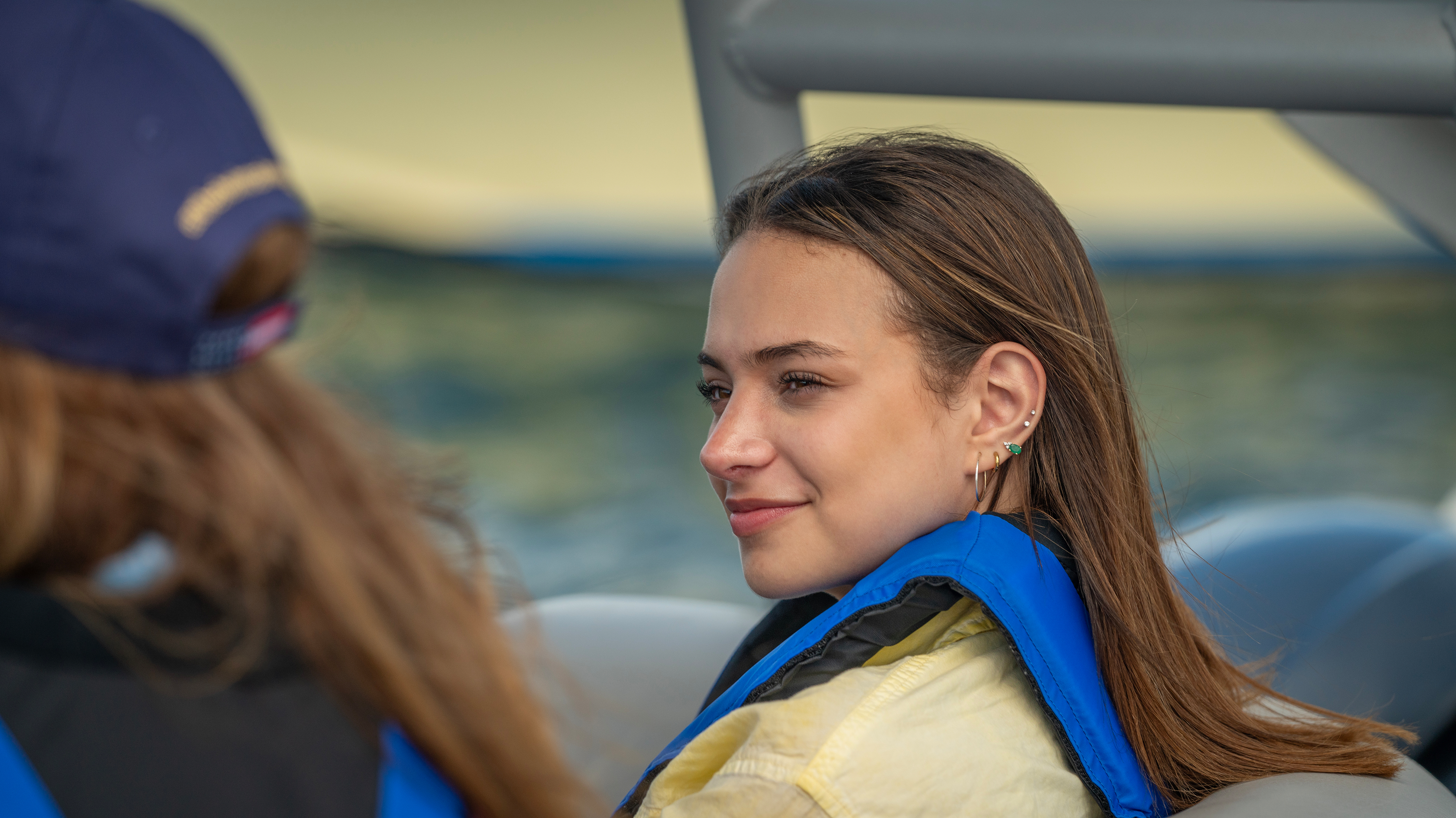 A woman wearing a life jacket while on a boat, Type 3 life jackets concept. 