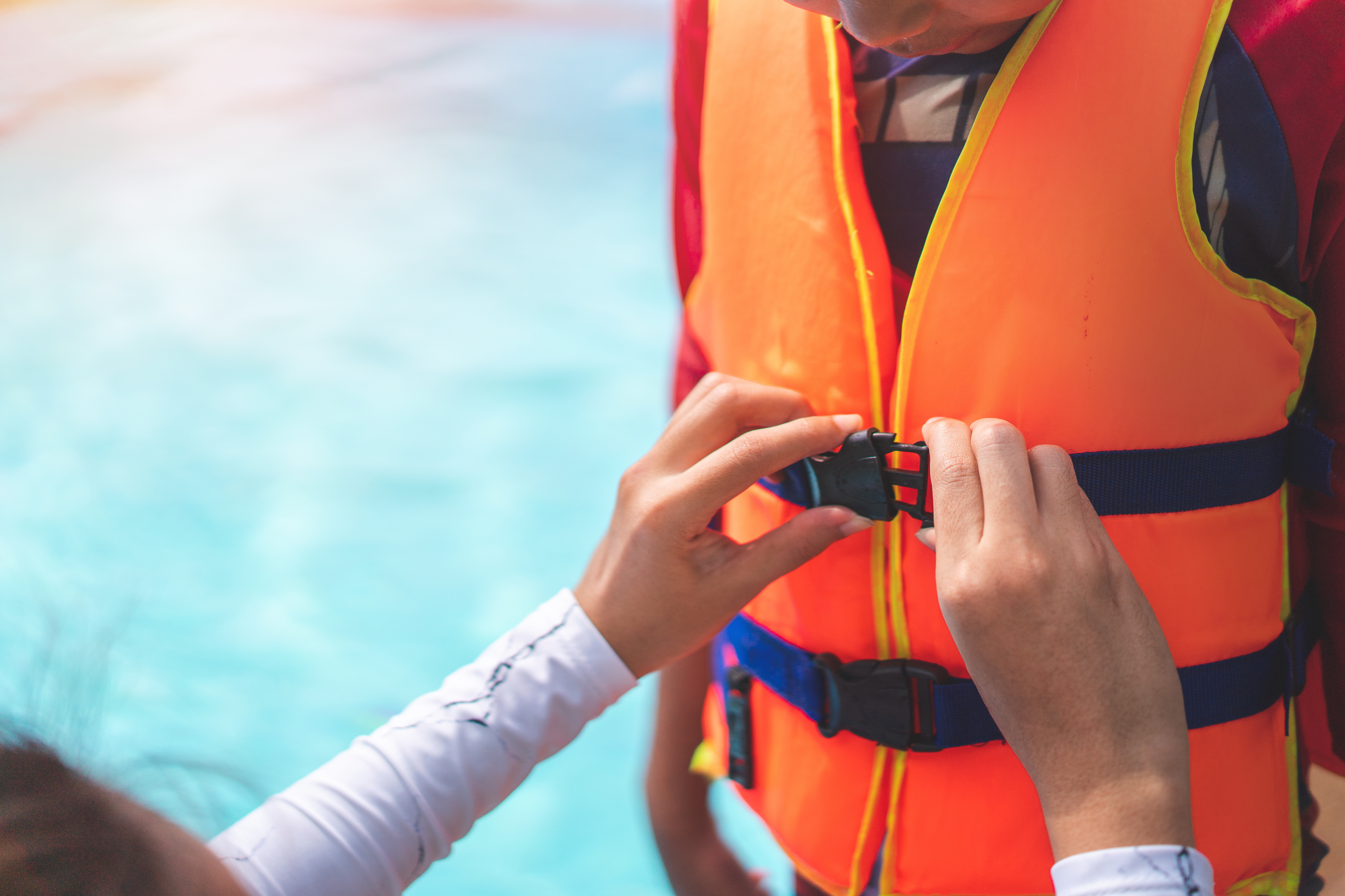 Close-up of someone fastening a lifejacket on a child, safety equipment for yachts concept. 