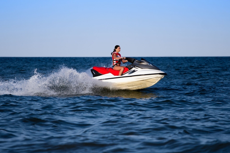 A women wearing a lifejacket while driving a jetski, PWC safety concept. 