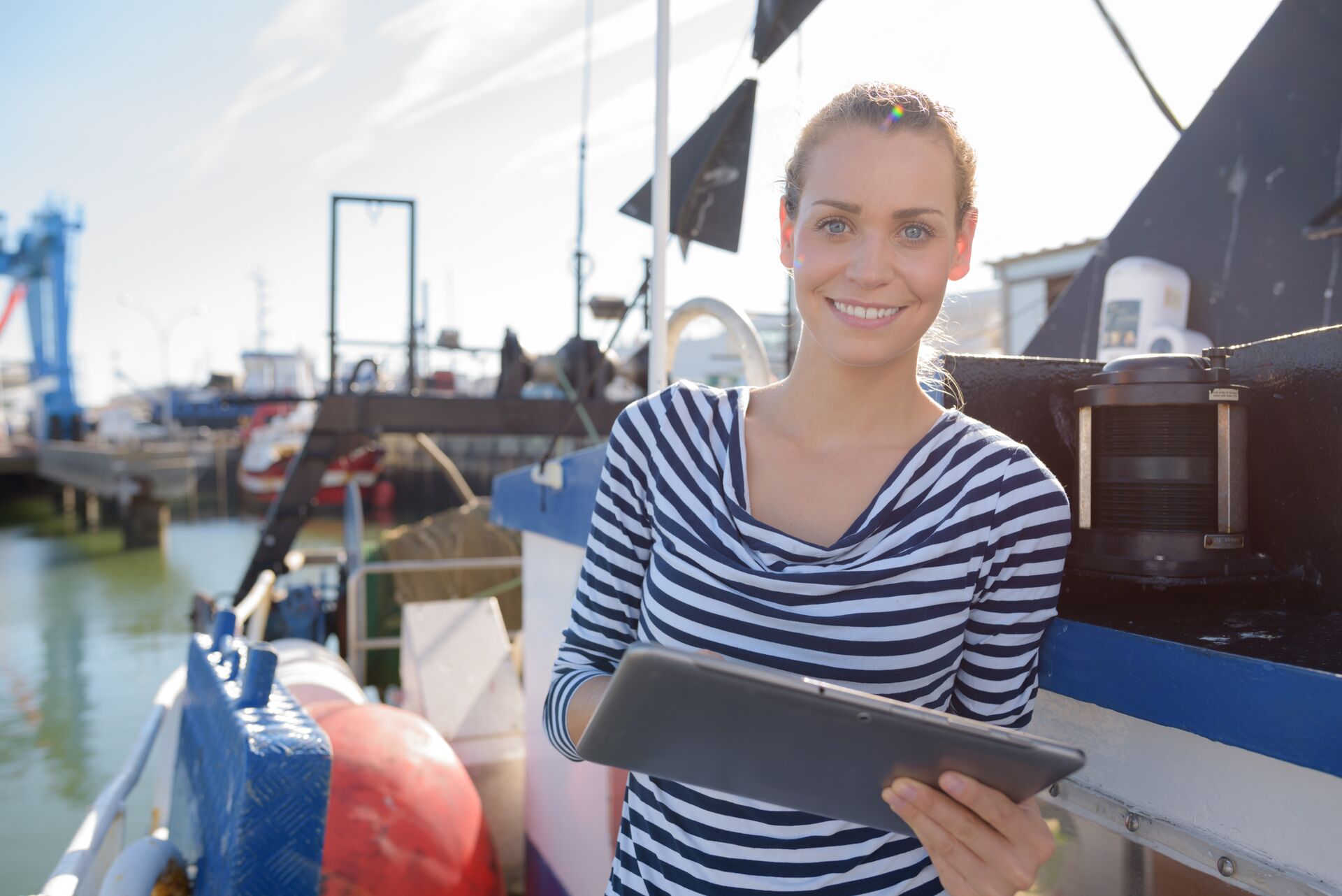 A woman on a boat with a tablet, boat rental agreement concept. 