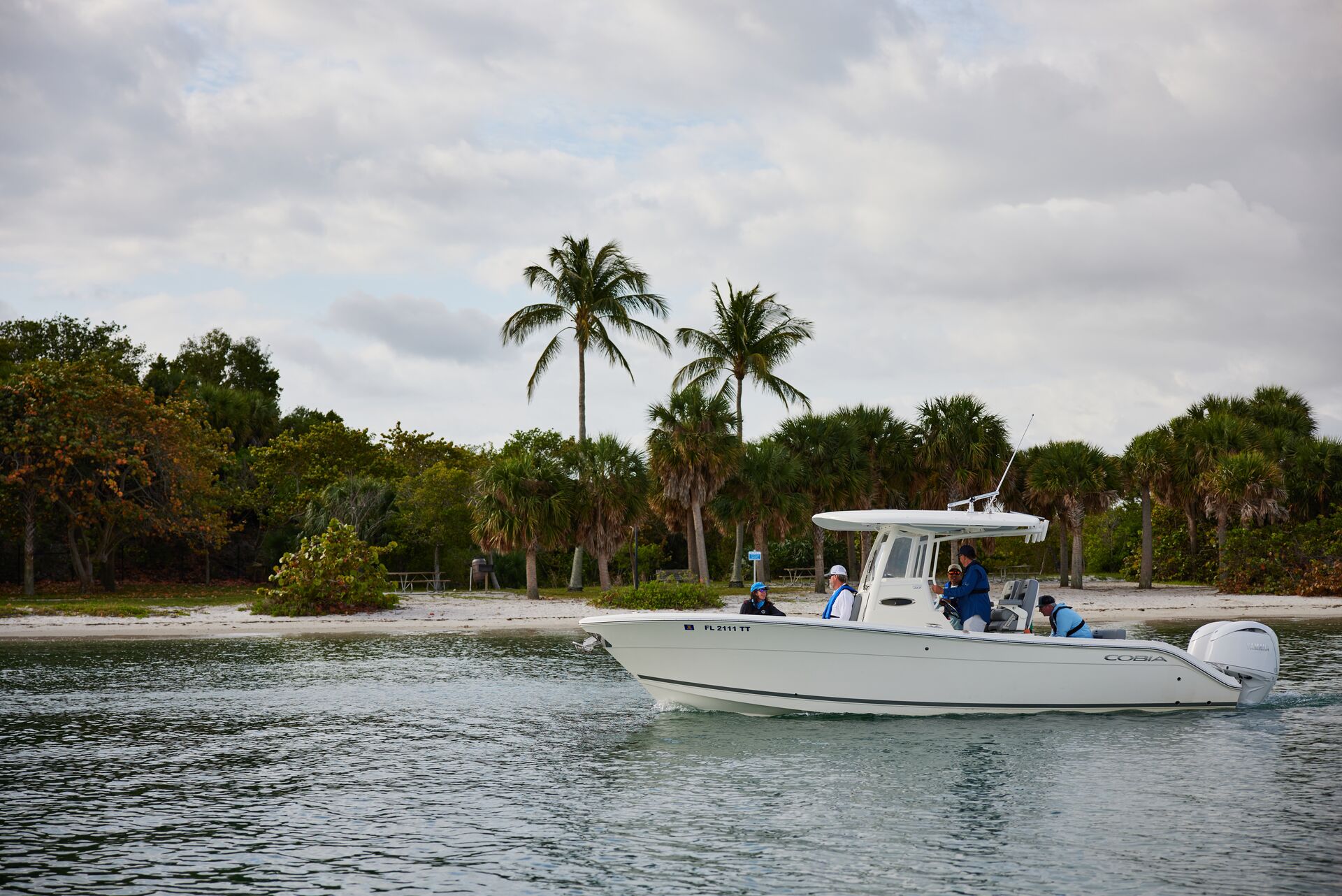 A boat full of people moves along a shore, make sure your boat has a fire extinguisher concept. 