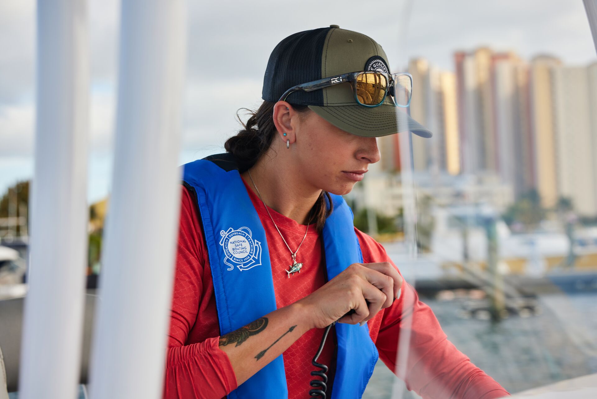 A woman in a Type 2 life jacket uses a boat radio. 