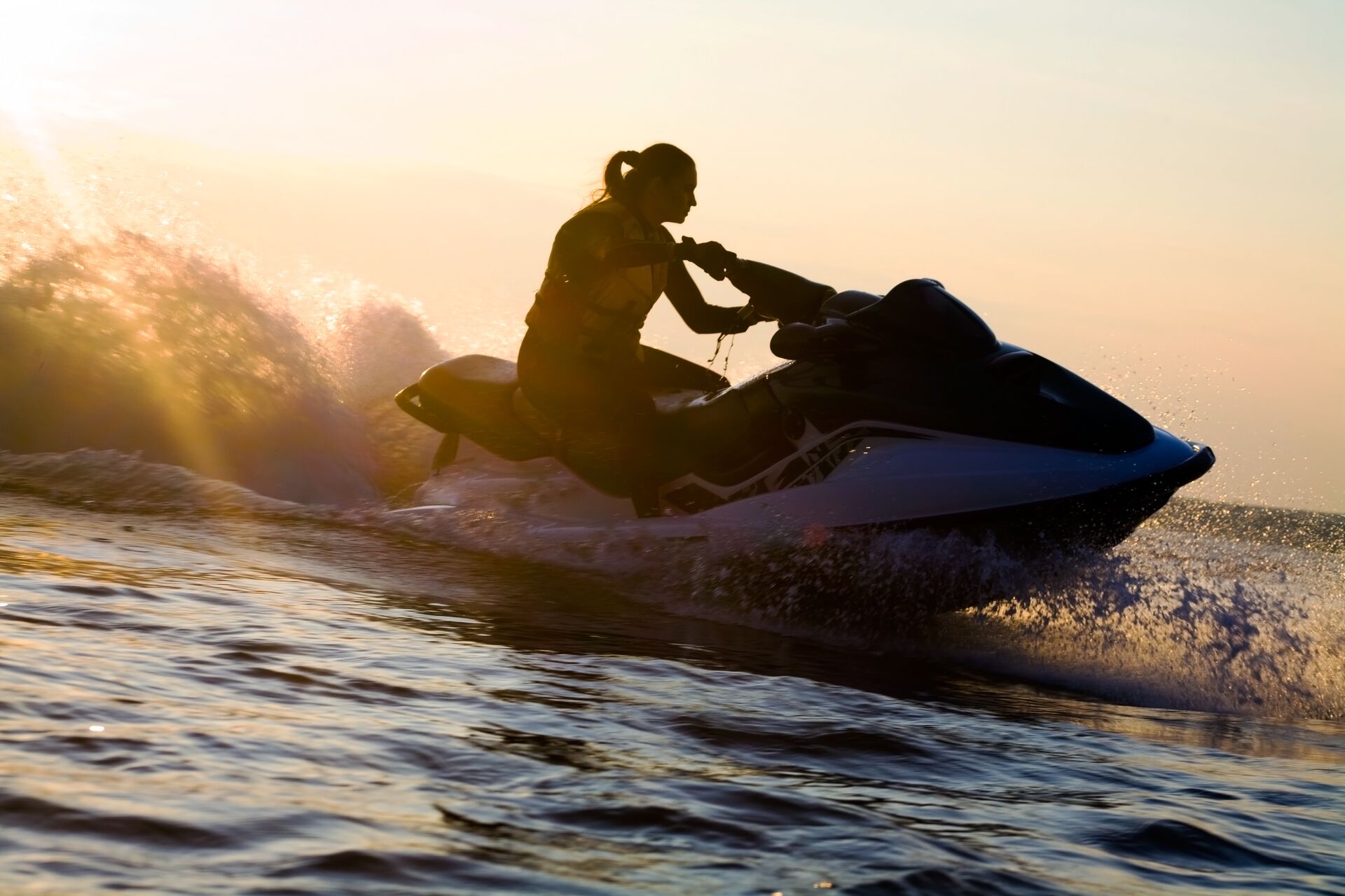 Silhouette of a woman on a jet ski on the water. 