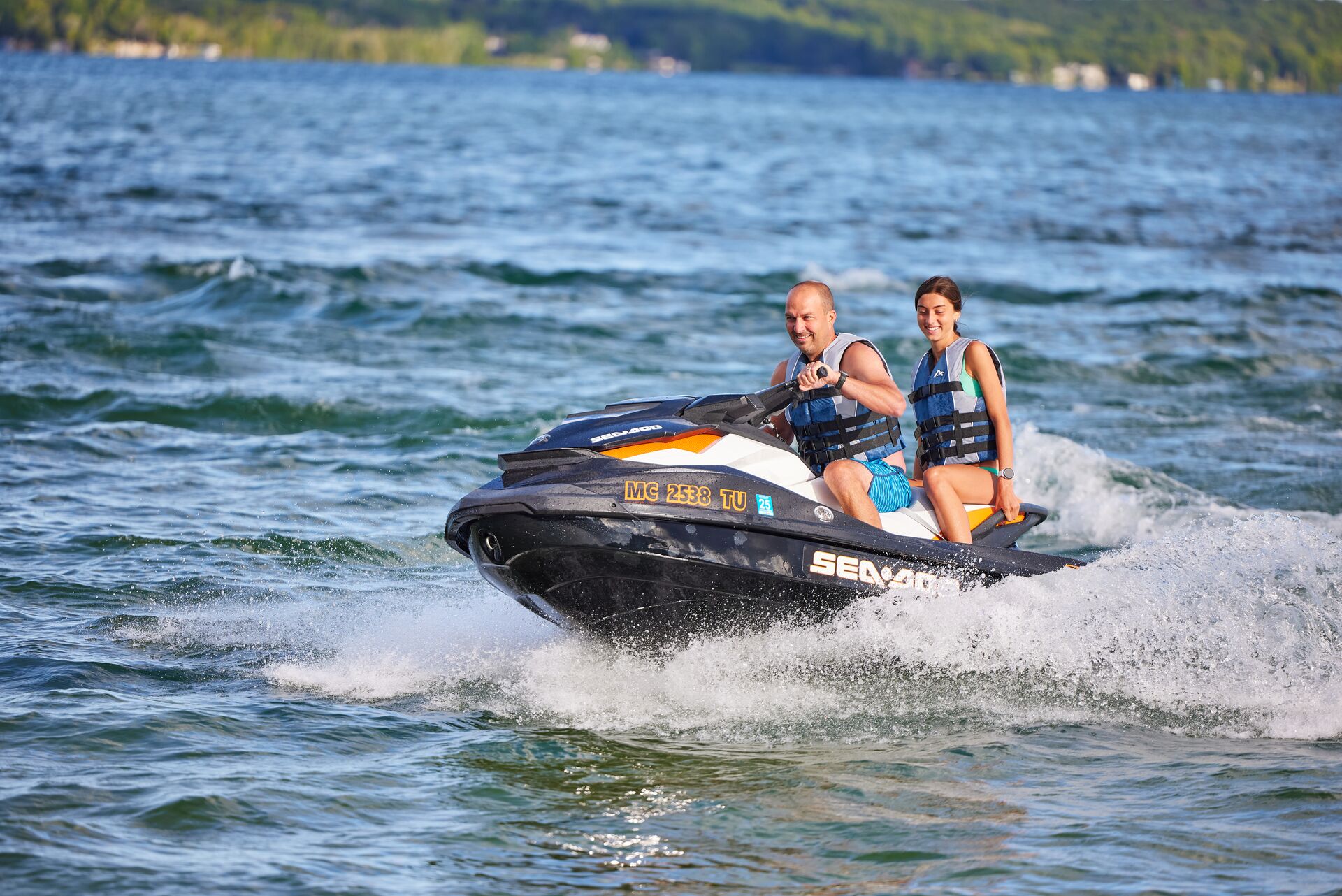 A man and girl riding a jet ski. 