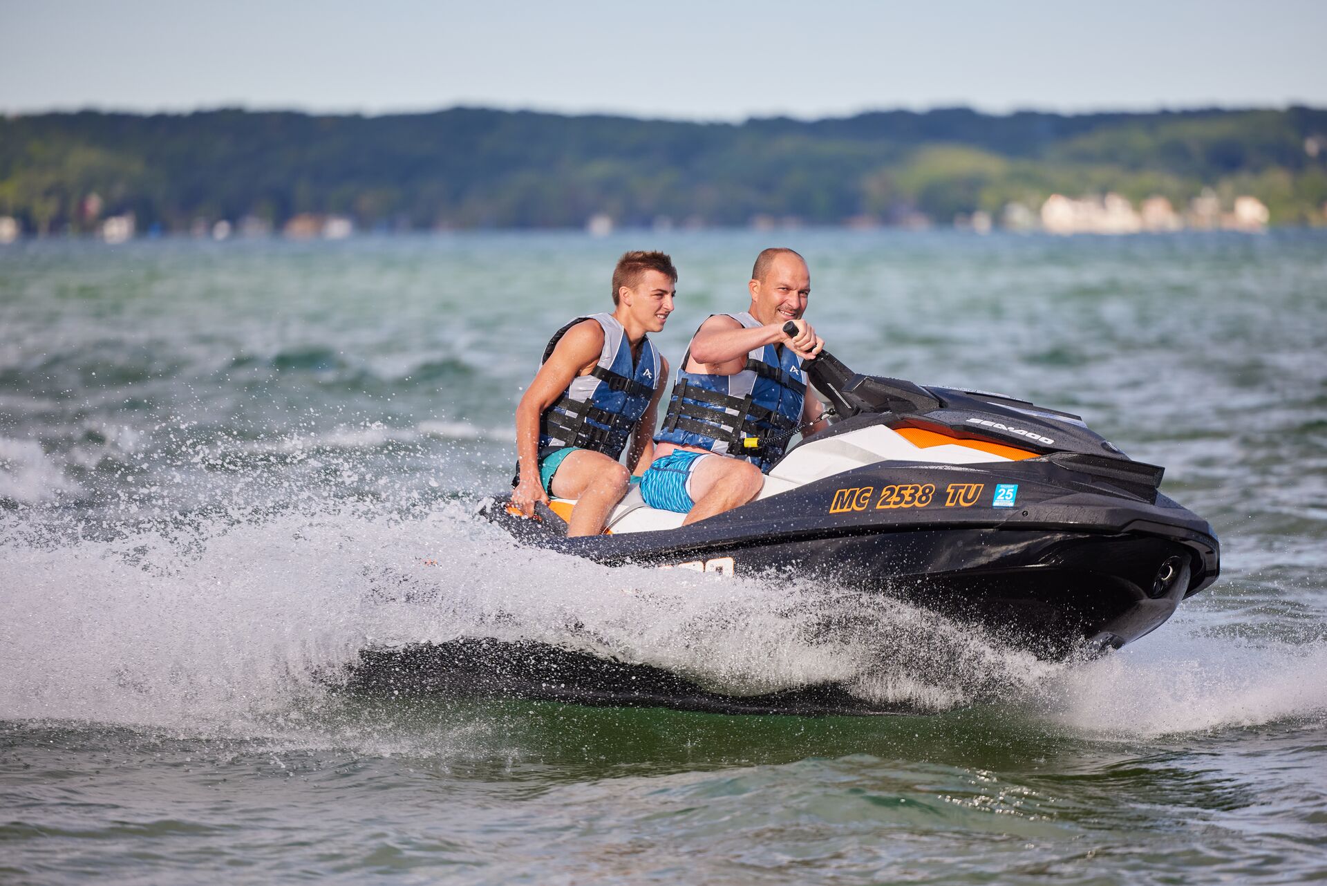 Two guys on a jet ski on the water. 