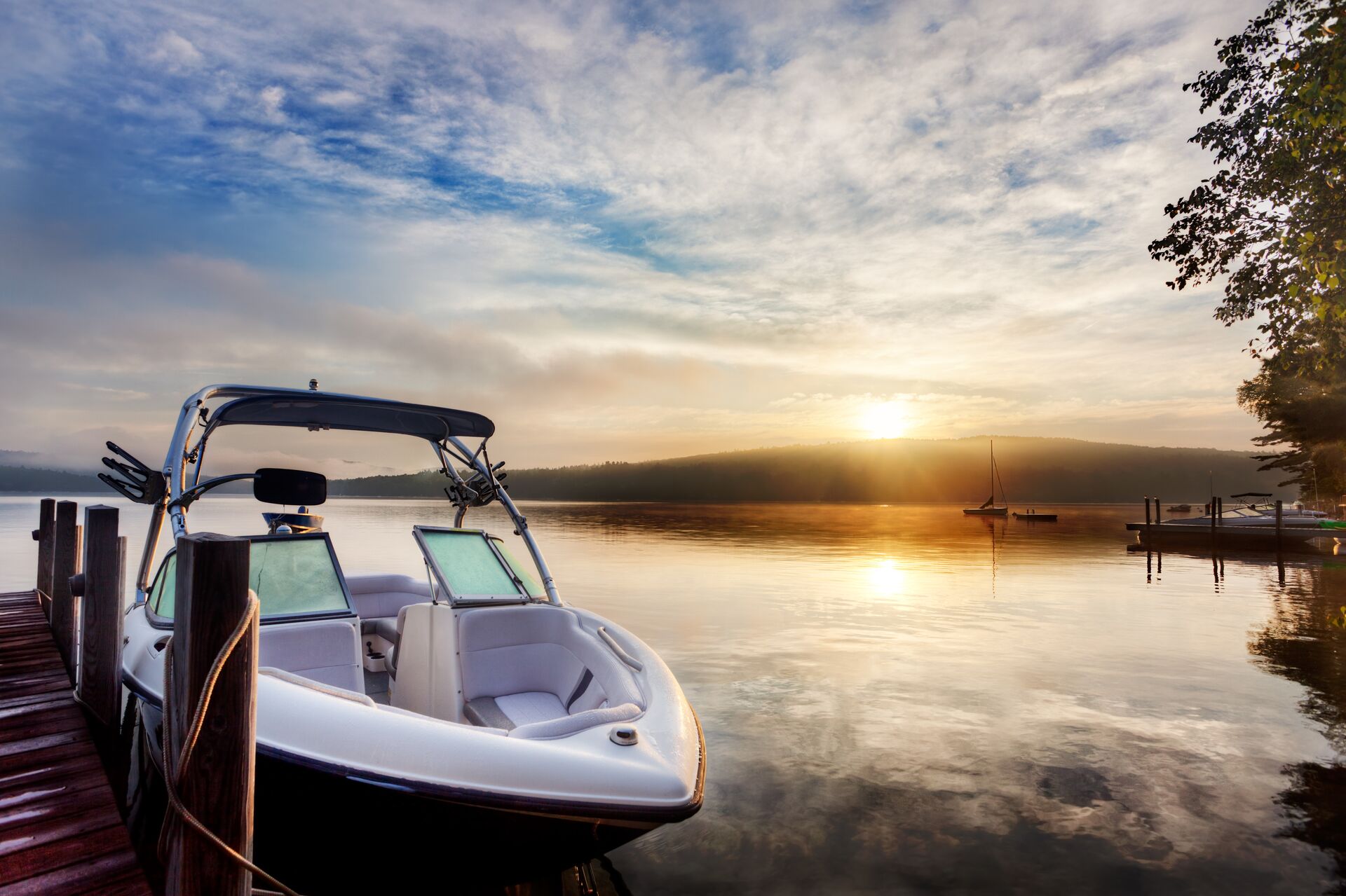 A jet boat at a dock at sunset. 