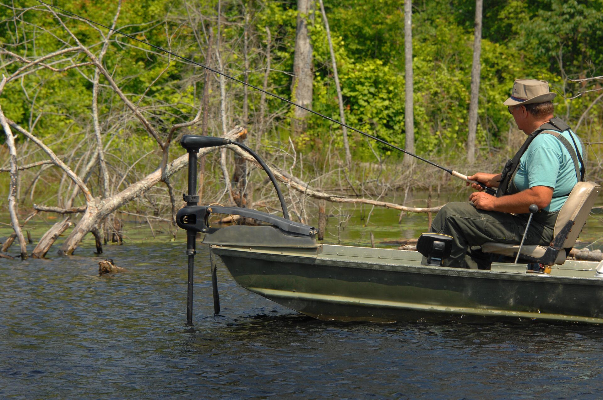 An angler in a boat with a trolling motor.