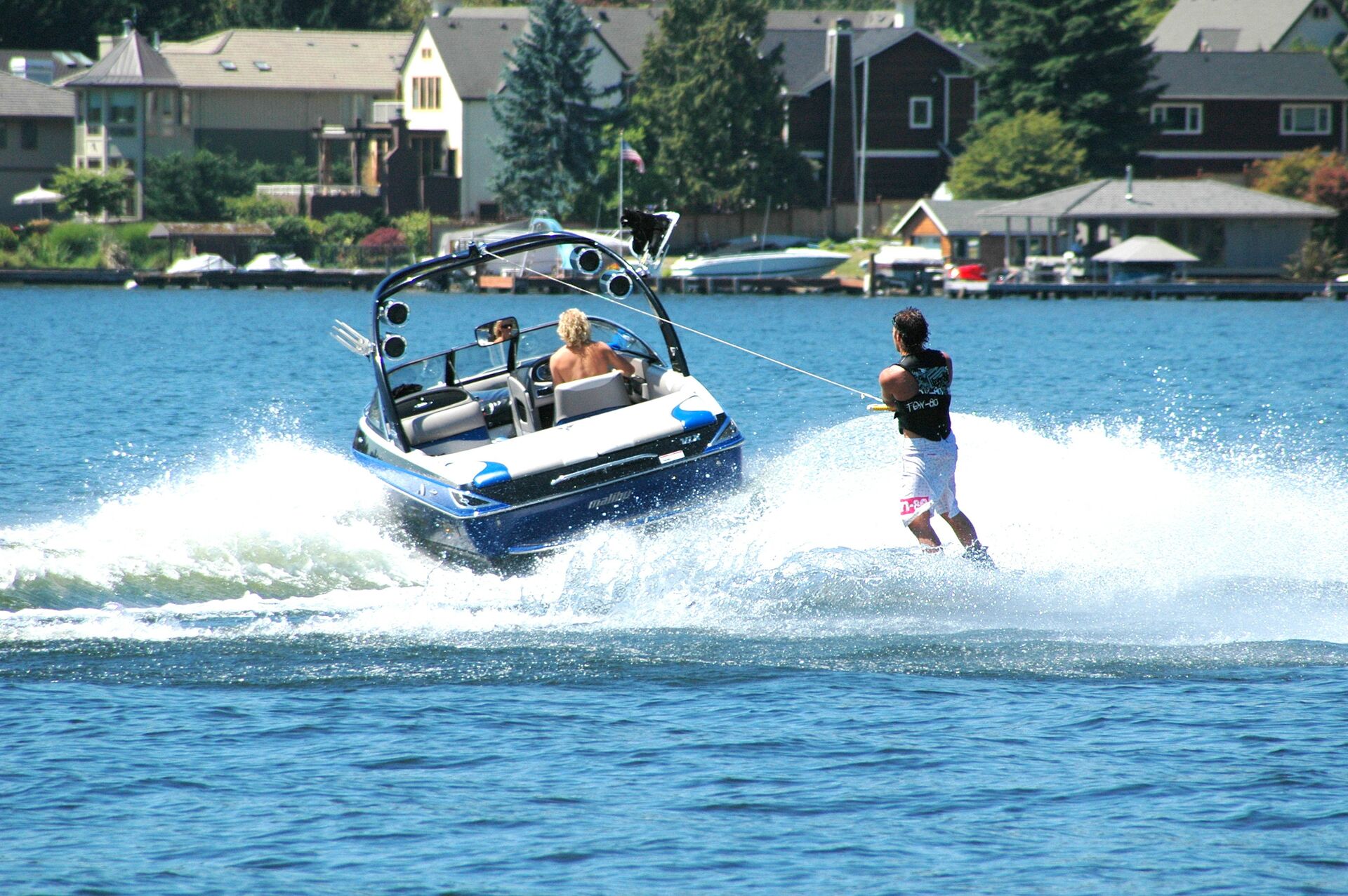 A fish and ski boat pulls a person on water skis. 