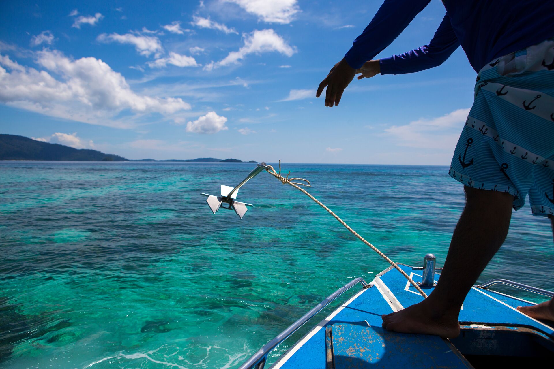 A boater throws an anchor into the water, what is a boat anchor concept. 